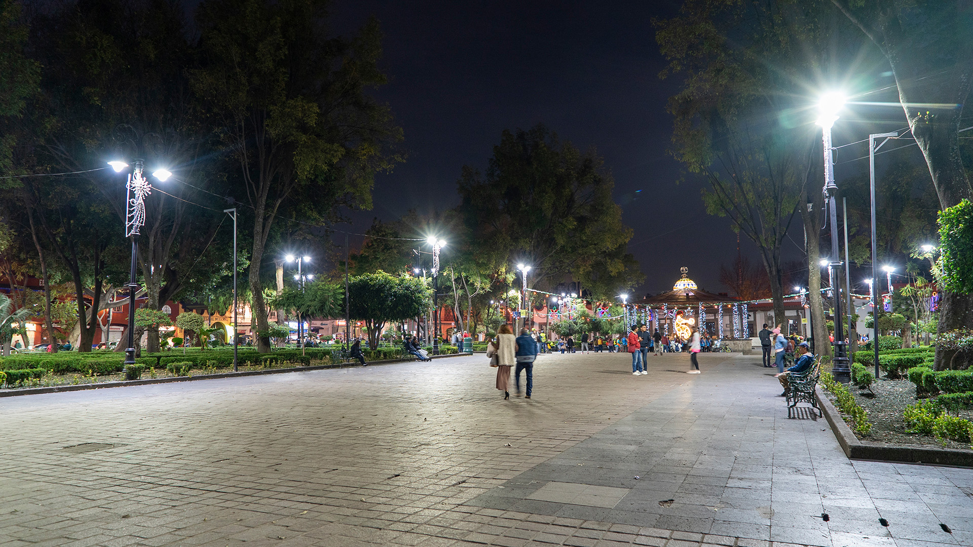 Personas caminando en parque con iluminación de Espacios Recreativos Coyoacán