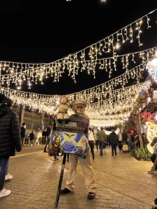 Organillero tocando musica en la calle 16 de Septiembre, Centro histórico de Puebla con Iluminación de temporada Navideña