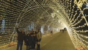 Familia disfrutando del túnel de luces, una de las atracciones principales del Sendero Iluminado en Puebla.